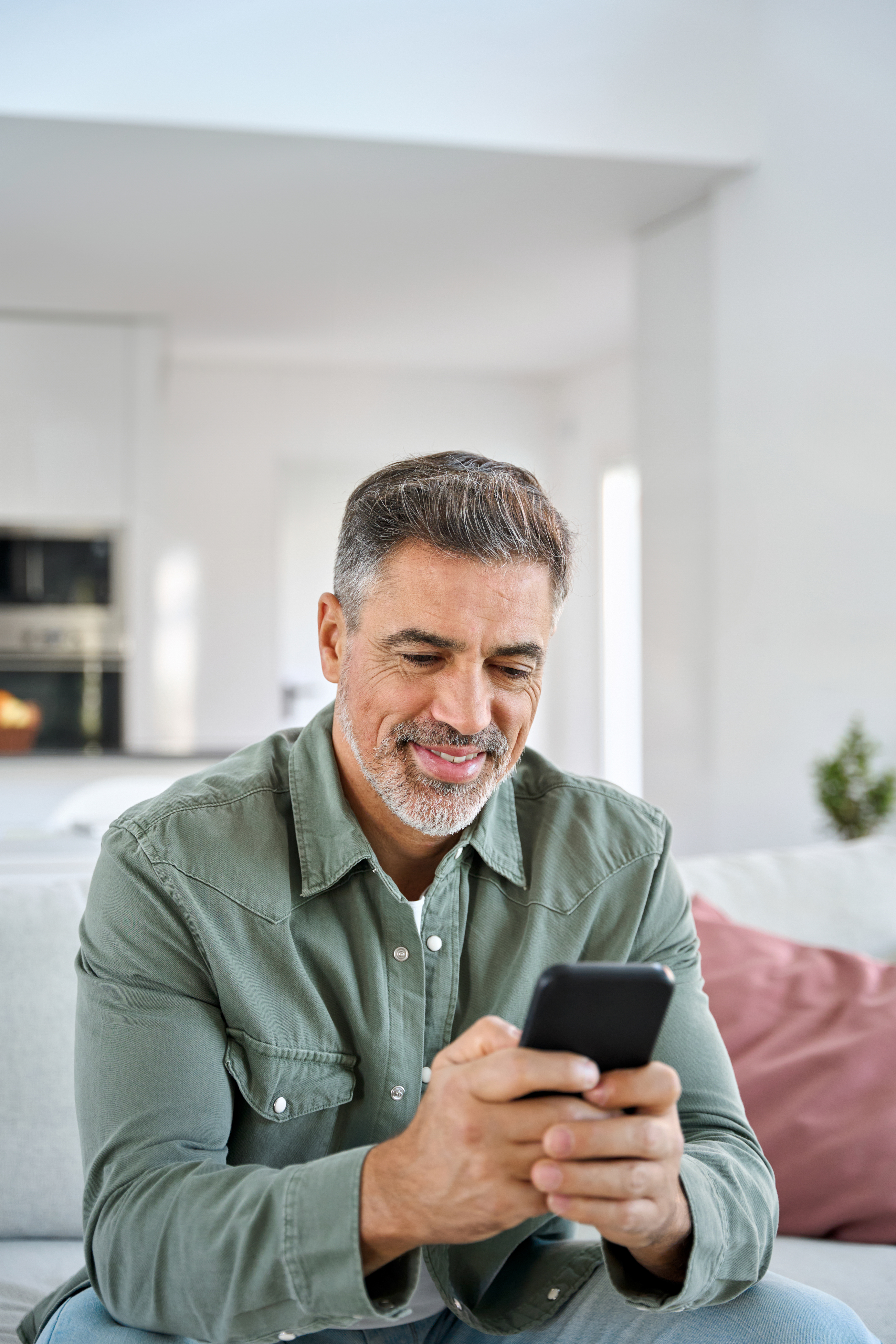 Man using phone to book a gynecomastia appointment